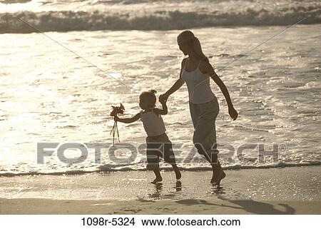 Picture - sand, people, water, walking, mother, beach, silhouette. Fotosearch