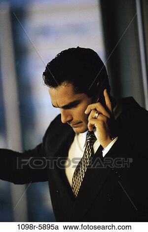 Stock Image - talking, Hispanic, business, Middle-aged, serious, cell phone. Fotosearch