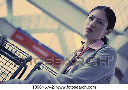 Stock Image - woman, sitting, Hispanic, business, waiting, indoors. Fotosearch