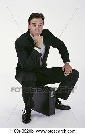 Stock Image - briefcase, sitting, business, Middle-aged, contemplation, thinking. Fotosearch