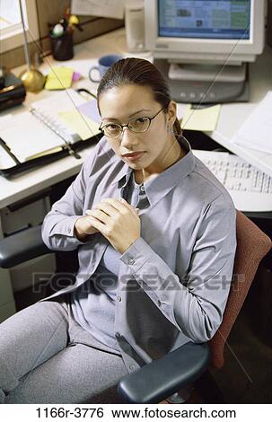 desk, woman, Asian, eyeglasses, business, serious, casual View Large Photo Image Stock Photograph - desk, woman, Asian, eyeglasses, business, serious, casual. Fotosearch