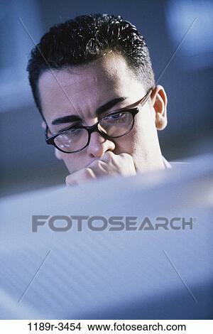 Picture - eyeglasses, computer, concentrating, business, serious, contemplating. Fotosearch