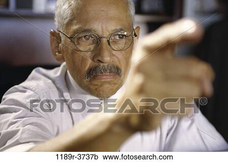 Stock Image - eyeglasses, Hispanic, pointing, business, point, Middle-aged. Fotosearch