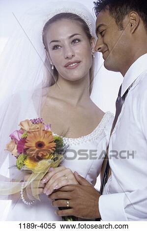 Stock Photography - hands, couple, Hispanic, flowers, commitment, wedding, bouquet. Fotosearch