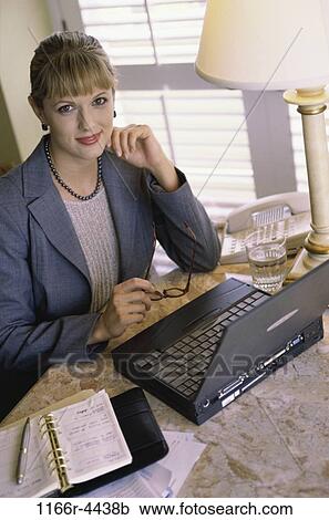 Stock Image - hotel, woman, eyeglasses, computer, appointment book, laptop, business. Fotosearch