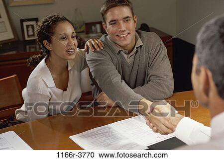 Stock Image - meeting, desk, consultation, Hispanic, handshake, young adult, Businesspeople consultations. Fotosearch