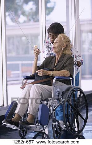 multiethnic, women, bottle, reading, patient, wheelchair, nurse View Large Photo Image Stock Photo - multiethnic, women, bottle, reading, patient, wheelchair, nurse. Fotosearch