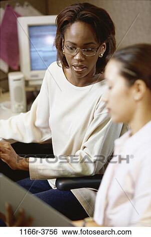 Stock Photograph - multiethnic, women, desk, computer, business, casual, indoors. Fotosearch