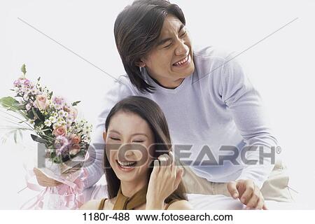 Stock Photo - people, Asian, couple, laughing, flowers, joyous, indoors. Fotosearch