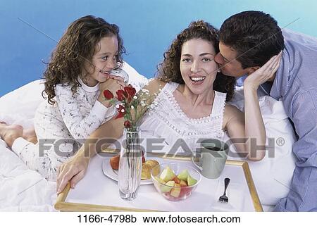 Stock Image - people, breakfast, bed, family, daughter, brunette. Fotosearch