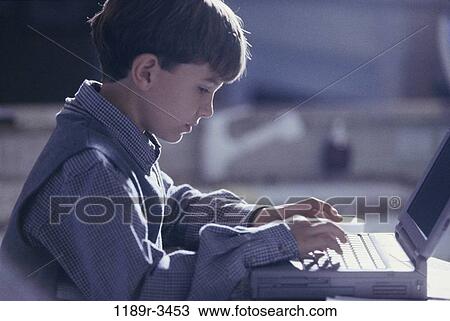Stock Image - people, computer, laptop, typing, concentrating, boy, serious. Fotosearch