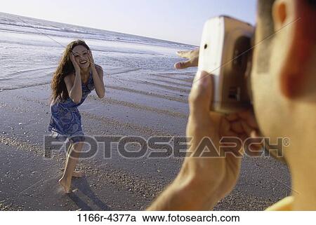 people, couple, beach, camera, posing, brunette, clothed View Large Photo Image Stock Image - people, couple, beach, camera, posing, brunette, clothed. Fotosearch