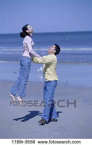 people, couple, beach, playful, lifting, jeans, clothed View Large Photo Image Stock Photo - people, couple, beach, playful, lifting, jeans, clothed. Fotosearch