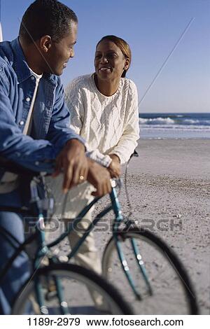 Stock Photo - people, couple, beach, riding, Middle-aged, bicycles, cycling. Fotosearch