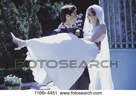 people, couple, outdoors, carrying, lifting, commitment, wedding View Large Photo Image Stock Image - people, couple, outdoors, carrying, lifting, commitment, wedding. Fotosearch
