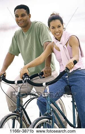 Stock Image - people, couple, riding, outdoors, bicycles, cycling, ride. Fotosearch