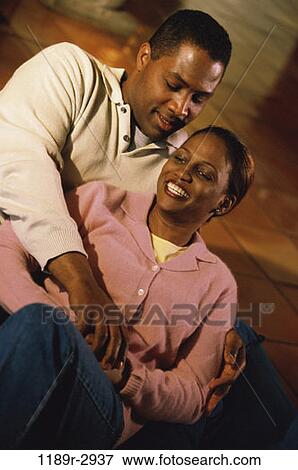 Stock Photo - people, couple, sitting, Middle-aged, indoors, African-American, sit. Fotosearch