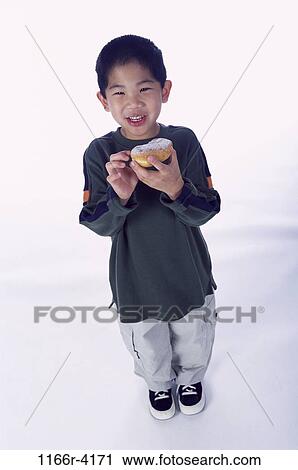 Stock Image - people, eating, Asian, boy, child, indoors, donut. Fotosearch