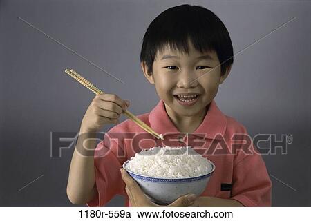 Stock Image - people, eating, Asian, chopsticks, boy, child, rice. Fotosearch