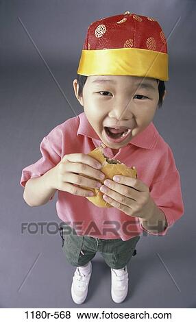 Stock Photo - people, eating, hat, Asian, hamburger, boy, child. Fotosearch