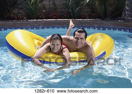 Stock Image - people, floating, pool, couple, raft, outdoors, Middle-aged. Fotosearch