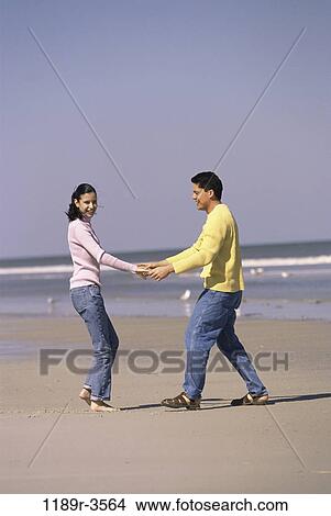 Picture - people, hands, couple, beach, holding, jeans, clothed. Fotosearch