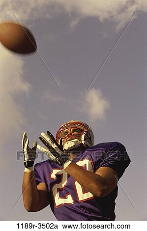 Stock Image - people, helmet, ball, football, catching, receiver. Fotosearch