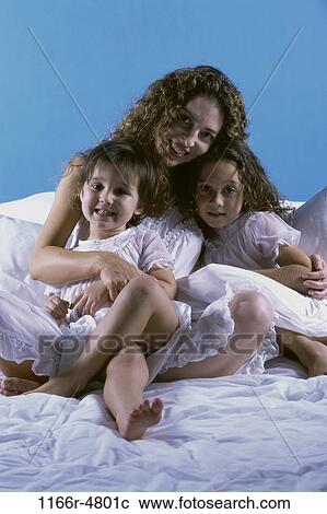 Stock Image - people, mother, bed, family, brunette, parent. Fotosearch