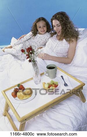 Stock Image - people, mother, breakfast, bed, family, daughter. Fotosearch