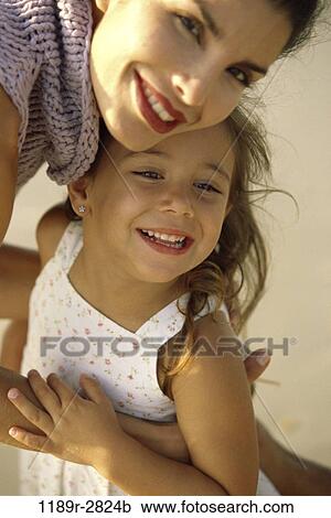 Stock Image - people, mother, Hispanic, holding, family, daughter, brunette. Fotosearch