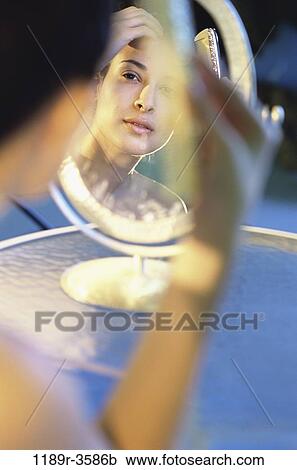 Stock Image - people, reflection, woman, Hispanic, mirror, beauty, combing. Fotosearch
