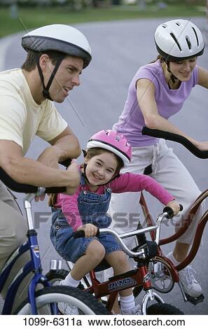 Stock Image - people, riding, outdoors, bicycles, family, daughter, helmets. Fotosearch