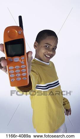Stock Image - people, telephone, phone, holding, boy, child, cell phone. Fotosearch