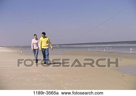 Stock Image - people, walking, couple, beach, jeans, clothed, sweaters. Fotosearch