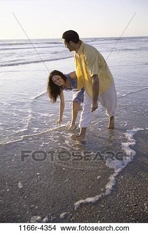 people, walking, couple, beach, splash, playful, splashing View Large Photo Image Picture - people, walking, couple, beach, splash, playful, splashing. Fotosearch