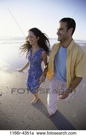 Stock Image - people, walking, couple, beach, brunette, clothed, walk. Fotosearch