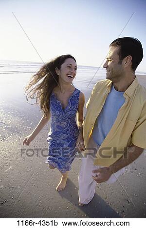 Stock Image - people, walking, couple, beach, brunette, clothed, walk. Fotosearch