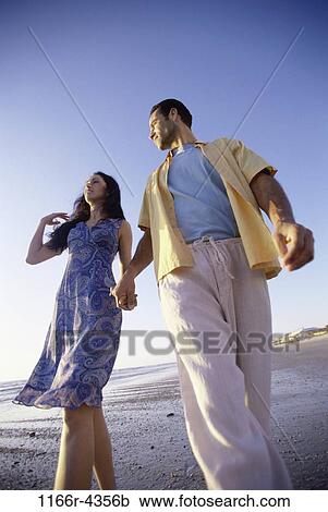 Stock Image - people, walking, couple, beach, brunette, clothed, walk. Fotosearch