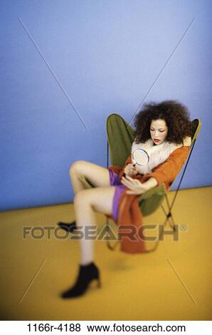 Stock Photo - people, woman, brunette, fashion, magnifying glass, indoors, young adult. Fotosearch