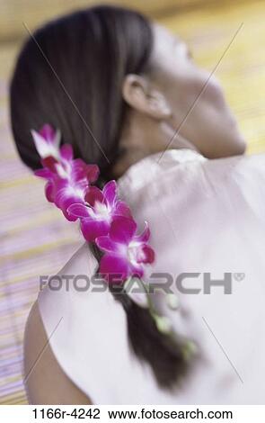Stock Image - people, woman, Hispanic, brunette, indoors, orchids, young adult. Fotosearch