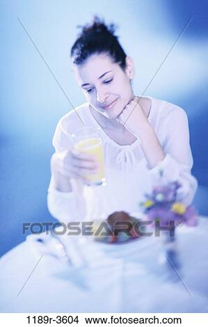 Picture - people, woman, morning, Hispanic, orange, breakfast, drinking. Fotosearch