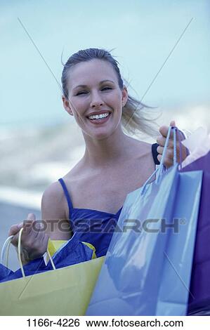 Stock Photograph - people, woman, outdoors, carrying, shopping, blond, shop. Fotosearch