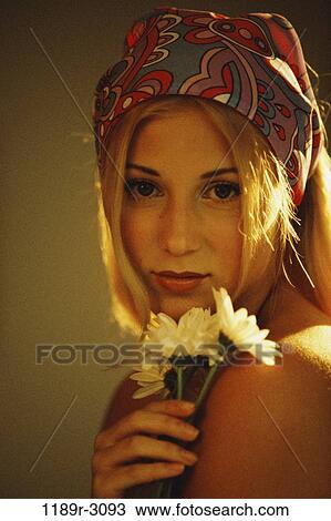 Stock Image - people, woman, pensive, daisies, bandana, blond, indoors. Fotosearch