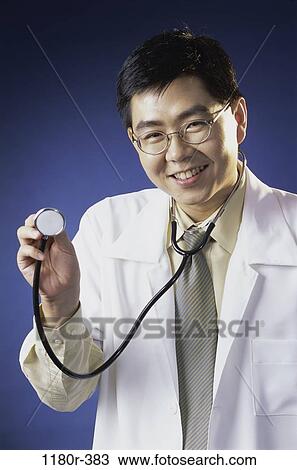Stock Image - physician, doctor, indoors, lab coat, stethoscope, Asian. Fotosearch