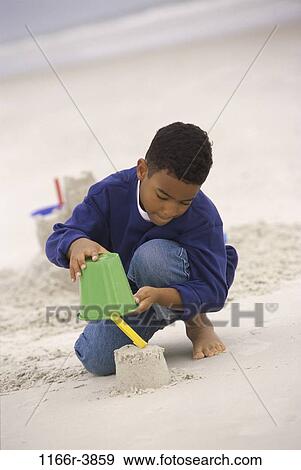 sand, people, building, playing, beach, sweater, boy View Large Photo Image Stock Photo - sand, people, building, playing, beach, sweater, boy. Fotosearch