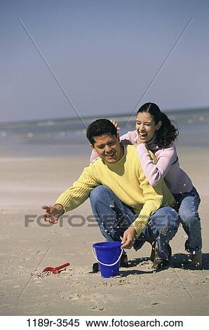sand, people, couple, beach, playful, jeans, clothed View Large Photo Image Stock Photography - sand, people, couple, beach, playful, jeans, clothed. Fotosearch