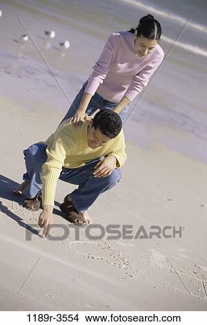 sand, people, couple, beach, writing, jeans, clothed View Large Photo Image Picture - sand, people, couple, beach, writing, jeans, clothed. Fotosearch