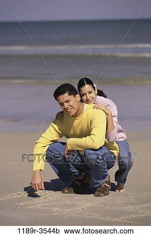 sand, people, couple, sitting, beach, writing, jeans View Large Photo Image Stock Image - sand, people, couple, sitting, beach, writing, jeans. Fotosearch