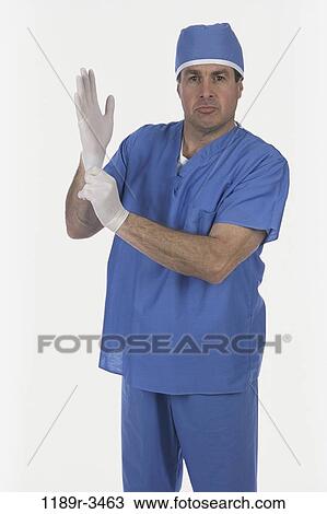 Stock Image - scrubs, doctor, surgeon, medicine, Middle-aged, gloves. Fotosearch