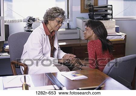 Stock Image - women, consultation, patient, doctor, diagnosis, nurturing, caring. Fotosearch